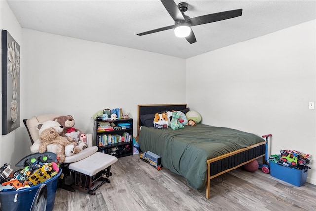 bedroom with hardwood / wood-style floors, a textured ceiling, and ceiling fan