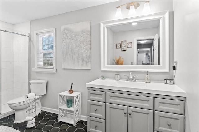 bathroom with vanity, tile patterned floors, toilet, and a tile shower