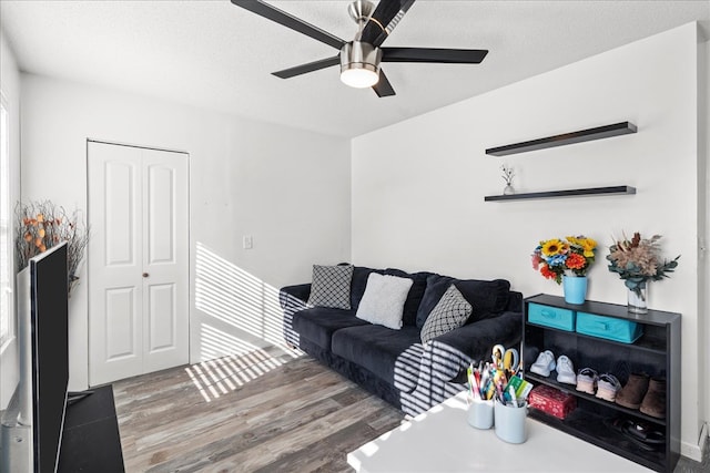 living room with ceiling fan, hardwood / wood-style floors, and a textured ceiling