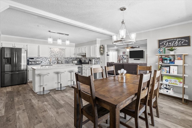 dining space with crown molding, hardwood / wood-style floors, a textured ceiling, and ceiling fan