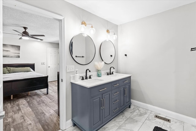 bathroom featuring vanity, ceiling fan, and a textured ceiling