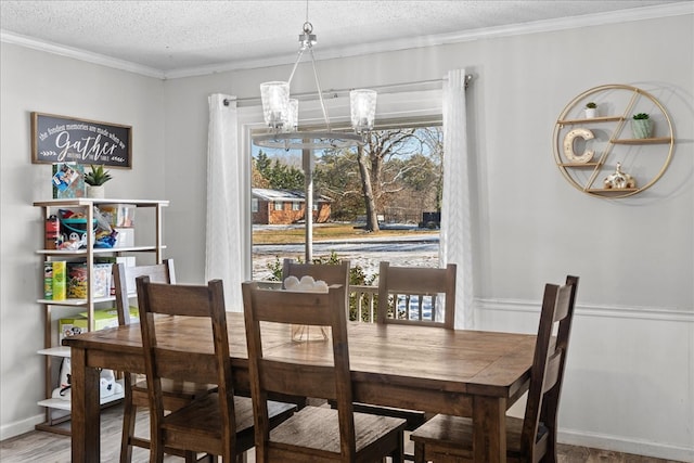 dining space featuring an inviting chandelier, hardwood / wood-style floors, ornamental molding, and a textured ceiling