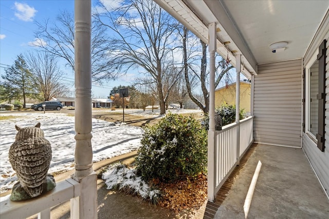 snowy yard featuring covered porch