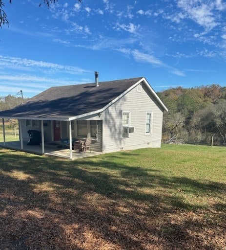 rear view of house with cooling unit, a yard, and a patio area