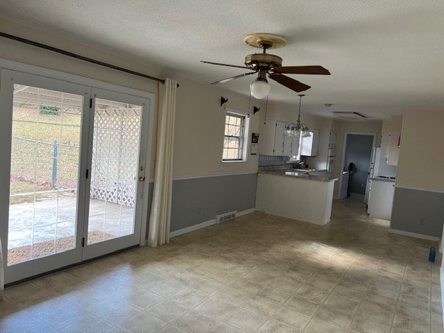 kitchen featuring ceiling fan, a textured ceiling, and white cabinets