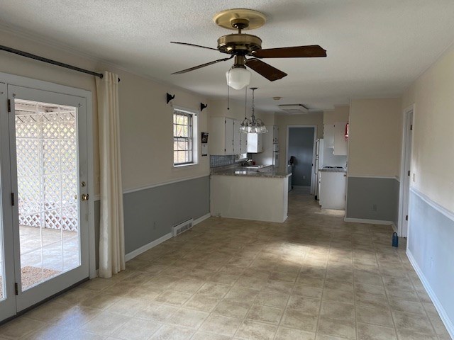 kitchen with ceiling fan, a textured ceiling, and white cabinets