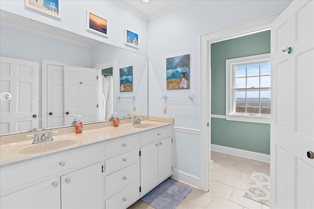 bathroom with double vanity, tile patterned floors, baseboards, and a sink