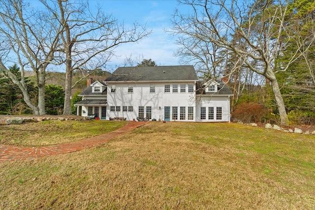 rear view of property with french doors, a yard, and a chimney