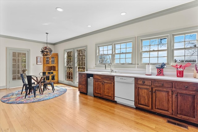 kitchen with dishwasher, light wood-type flooring, visible vents, and ornamental molding