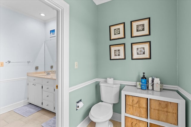 bathroom featuring vanity, toilet, baseboards, and tile patterned flooring