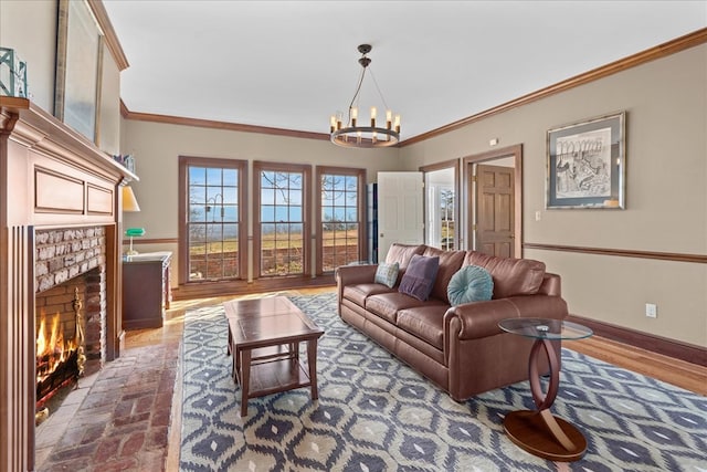 living room with a notable chandelier, a brick fireplace, baseboards, and ornamental molding