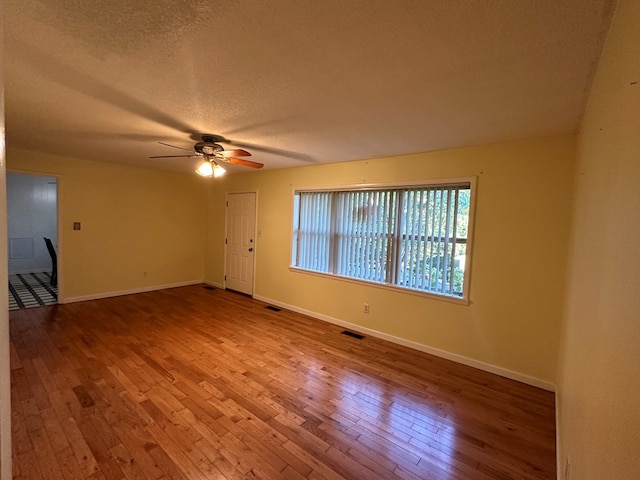 unfurnished room with hardwood / wood-style floors, a textured ceiling, and ceiling fan