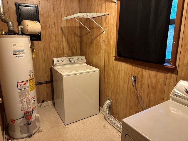 laundry room featuring gas water heater and wood walls