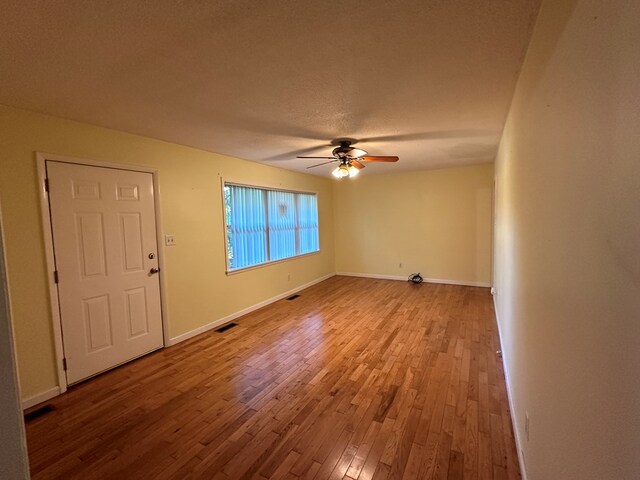 unfurnished room featuring ceiling fan, a textured ceiling, and light wood-type flooring