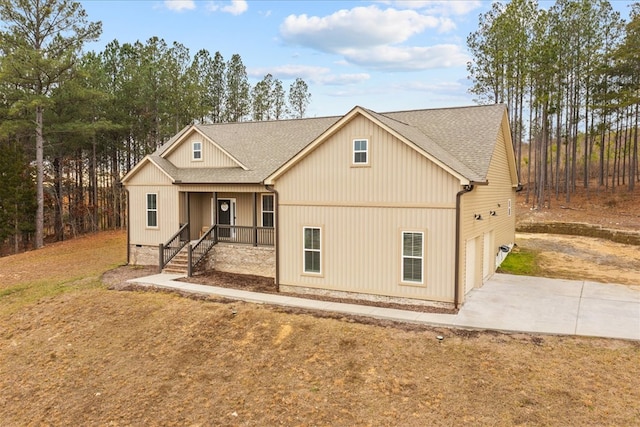 view of front of house with a garage, a front yard, and a porch