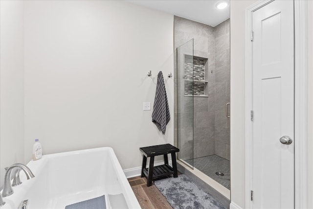 bathroom with hardwood / wood-style flooring and separate shower and tub