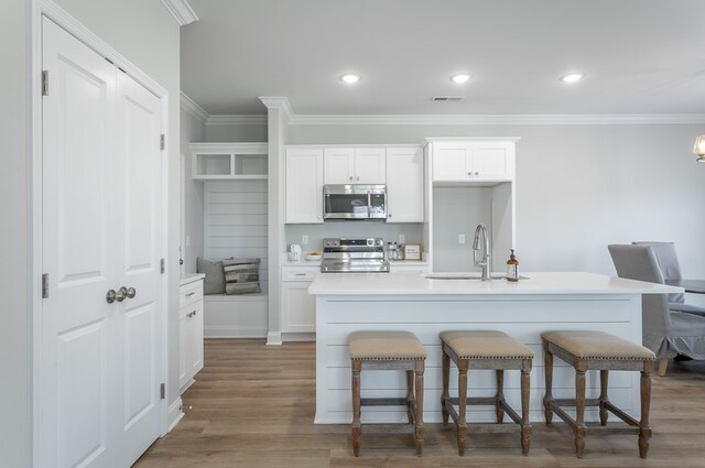 141 Andros Dr, Dalton, GA 30721 - kitchen featuring appliances with stainless steel finishes, a sink, ornamental molding, a kitchen breakfast bar, and a center island with sink