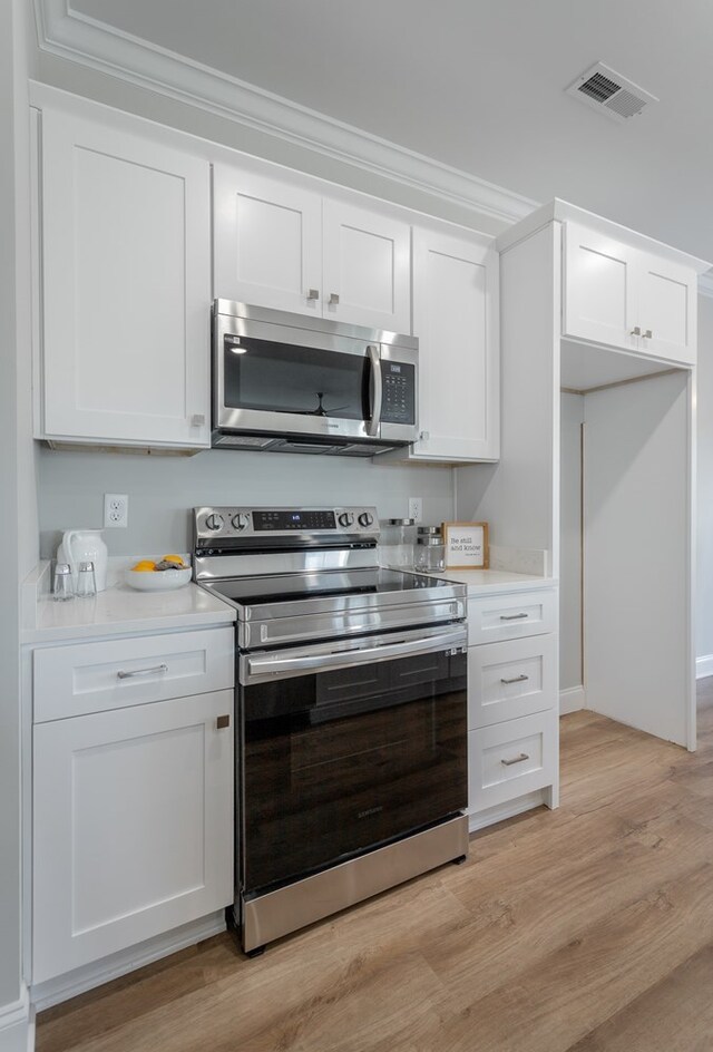 141 Andros Dr, Dalton, GA 30721 - kitchen featuring stainless steel appliances, light countertops, white cabinets, and crown molding