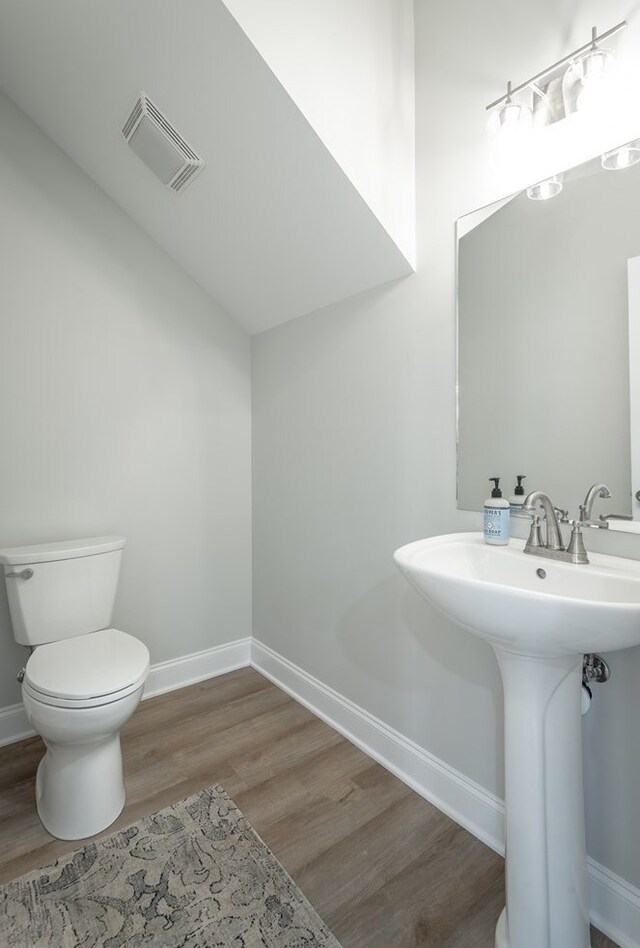 141 Andros Dr, Dalton, GA 30721 - half bathroom featuring wood finished floors, toilet, baseboards, and a sink