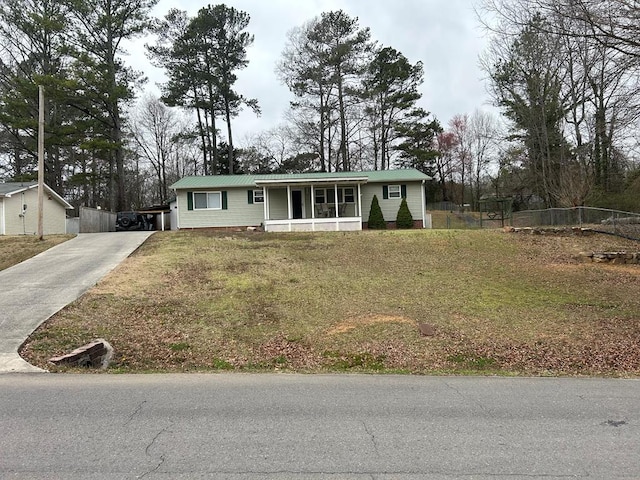 single story home with metal roof, covered porch, driveway, and fence