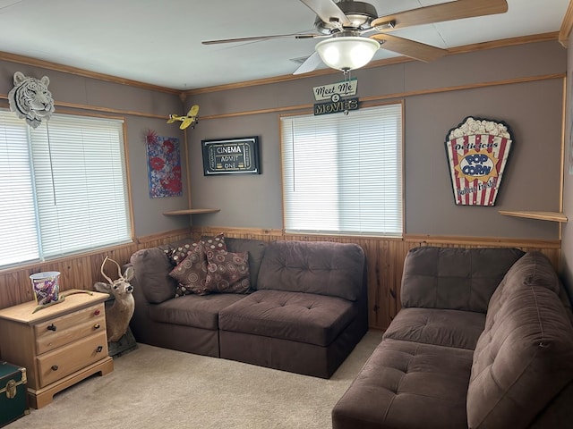 carpeted living area with wooden walls, plenty of natural light, and a wainscoted wall