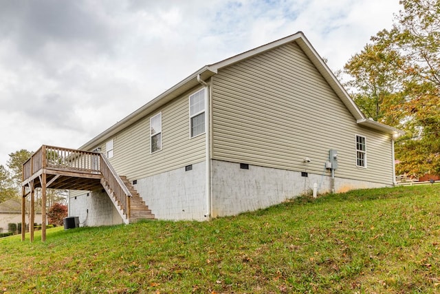 view of side of property featuring central AC unit, a yard, and a deck