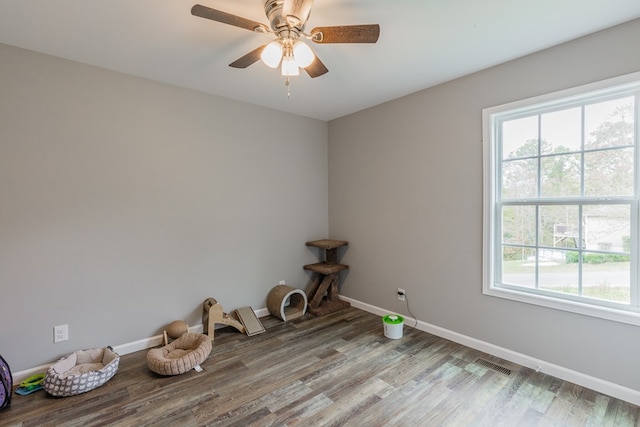 empty room with hardwood / wood-style flooring, ceiling fan, and a healthy amount of sunlight