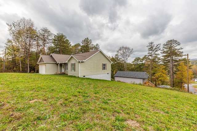 back of property with a garage and a lawn