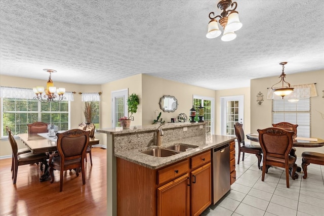 217 Valley Rd, Chatsworth, GA 30705 - kitchen featuring a chandelier, stainless steel dishwasher, brown cabinets, pendant lighting, and a textured ceiling