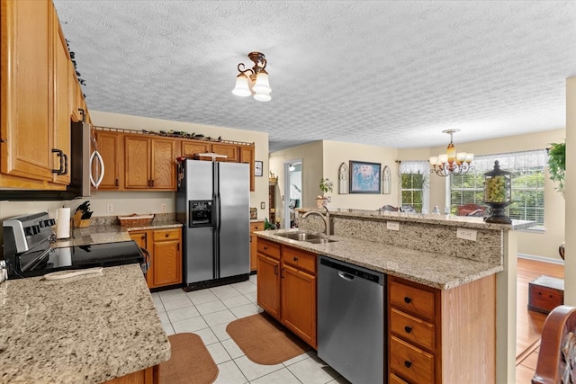 217 Valley Rd, Chatsworth, GA 30705 - kitchen with appliances with stainless steel finishes, a chandelier, a textured ceiling, brown cabinets, and light tile patterned floors