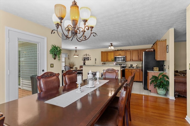 217 Valley Rd, Chatsworth, GA 30705 - dining space featuring a chandelier, light wood finished floors, and a textured ceiling