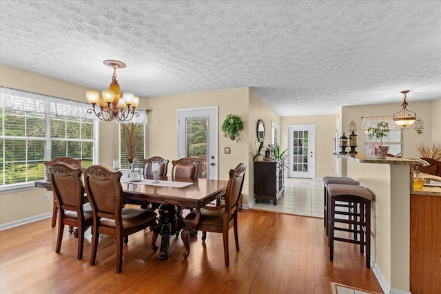 217 Valley Rd, Chatsworth, GA 30705 - dining space with a chandelier, light wood-style flooring, plenty of natural light, and a textured ceiling