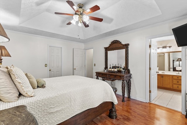 217 Valley Rd, Chatsworth, GA 30705 - bedroom with a tray ceiling, light wood finished floors, connected bathroom, ceiling fan, and crown molding