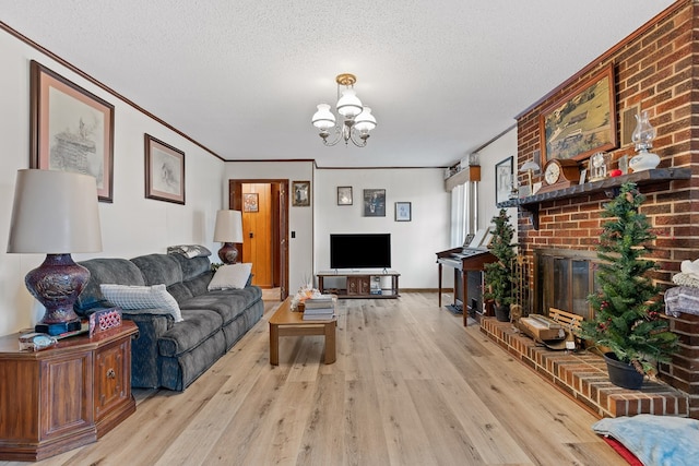 living room with crown molding, a fireplace, a textured ceiling, and light hardwood / wood-style flooring