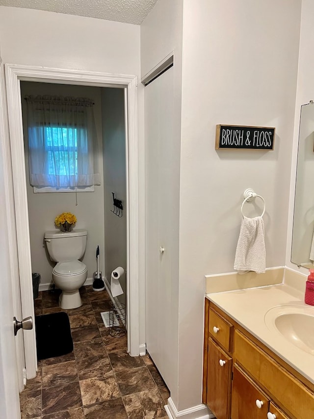 4781 Treetop Ln, Cohutta, GA 30710 - bathroom featuring vanity, toilet, baseboards, and stone finish flooring
