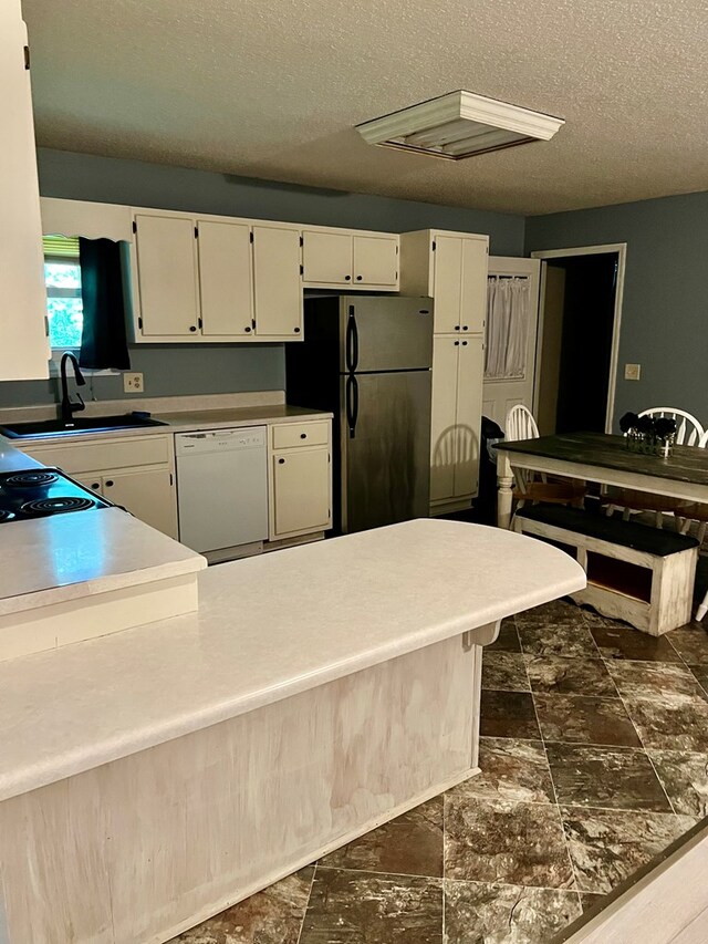 4781 Treetop Ln, Cohutta, GA 30710 - kitchen with freestanding refrigerator, white cabinetry, a sink, and dishwasher