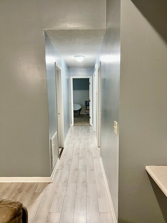 4781 Treetop Ln, Cohutta, GA 30710 - hallway featuring a textured ceiling, visible vents, light wood-style flooring, and baseboards
