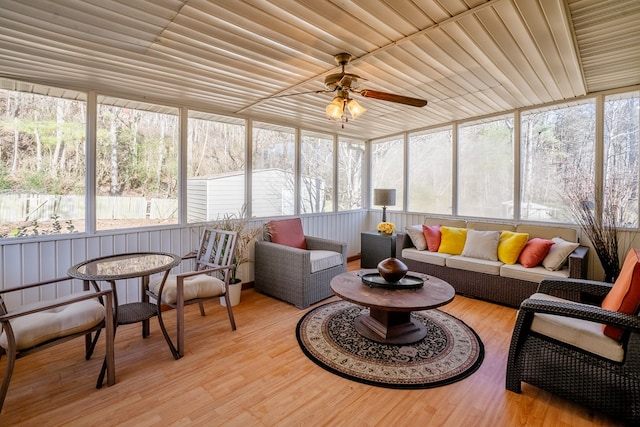 sunroom / solarium featuring a healthy amount of sunlight, wooden ceiling, and ceiling fan