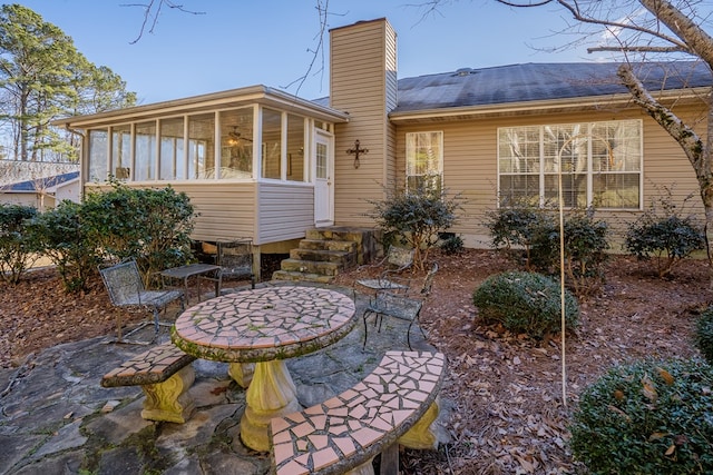 rear view of house featuring a sunroom and a patio