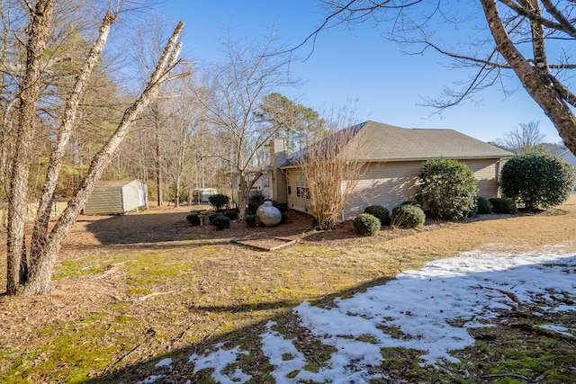 snow covered property with a storage unit