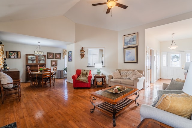 living room featuring hardwood / wood-style flooring, high vaulted ceiling, and ceiling fan