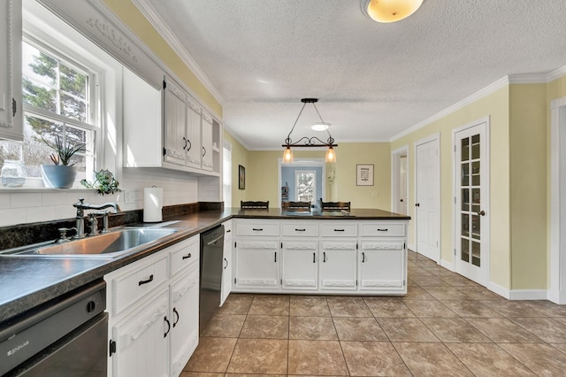 kitchen featuring dishwasher, dark countertops, crown molding, and a sink