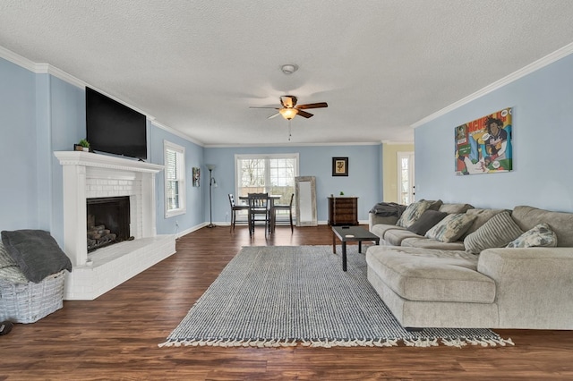 living room featuring a textured ceiling, dark wood finished floors, a fireplace, and ornamental molding