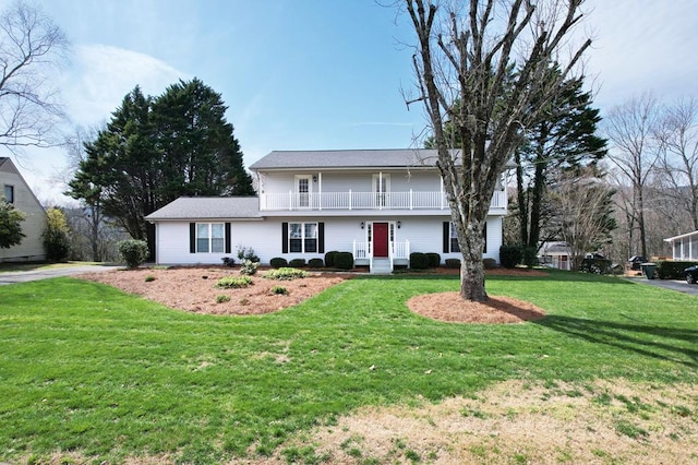 view of front of house with a balcony and a front lawn