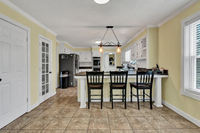 kitchen featuring dark countertops, a peninsula, stainless steel appliances, and a wealth of natural light