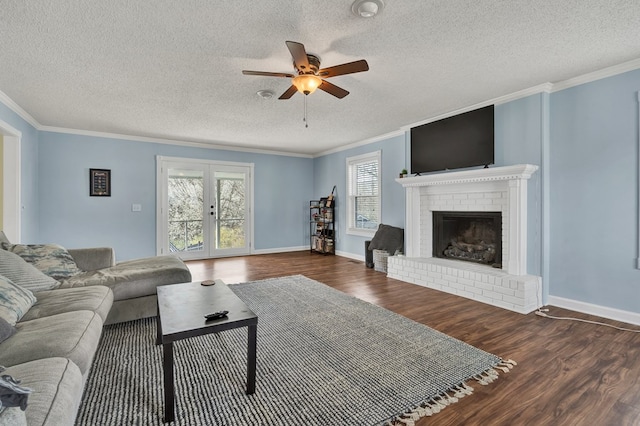 living room with ceiling fan, ornamental molding, french doors, a fireplace, and wood finished floors