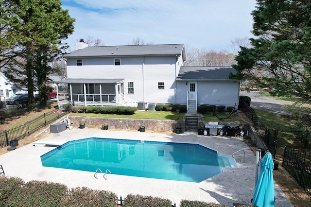 back of house featuring a fenced in pool, central AC, a chimney, a fenced backyard, and a sunroom