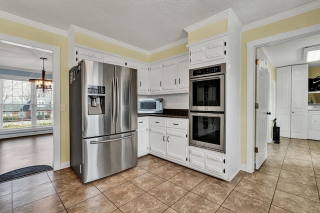 kitchen featuring white cabinetry, dark countertops, ornamental molding, and stainless steel appliances