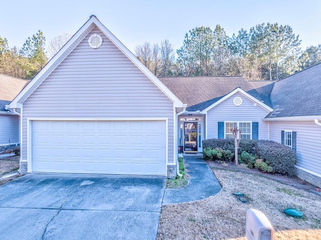 single story home with a garage, concrete driveway, and a shingled roof