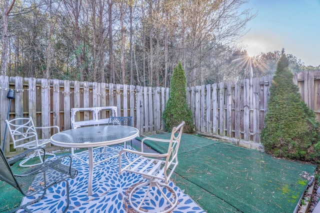 wooden terrace with outdoor dining space and a fenced backyard